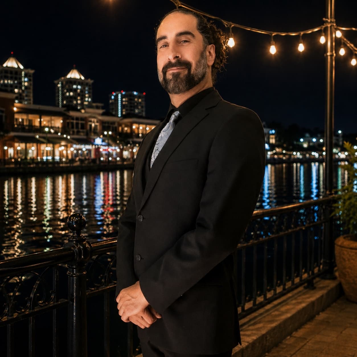 Daniel Imani in a black suit by the waterfront