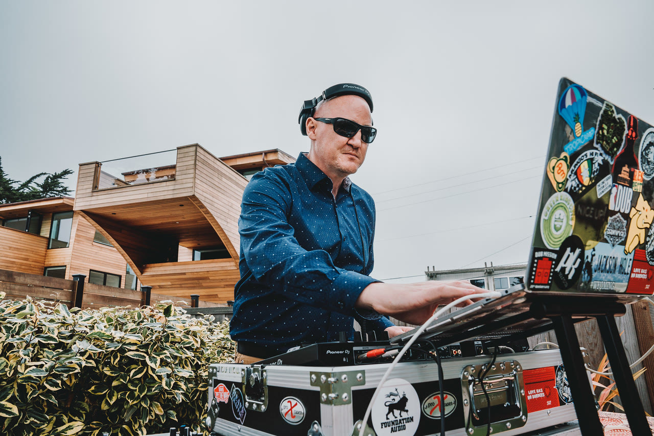 DJ LP Chillen performing in a blue button-down shirt at an outdoor event