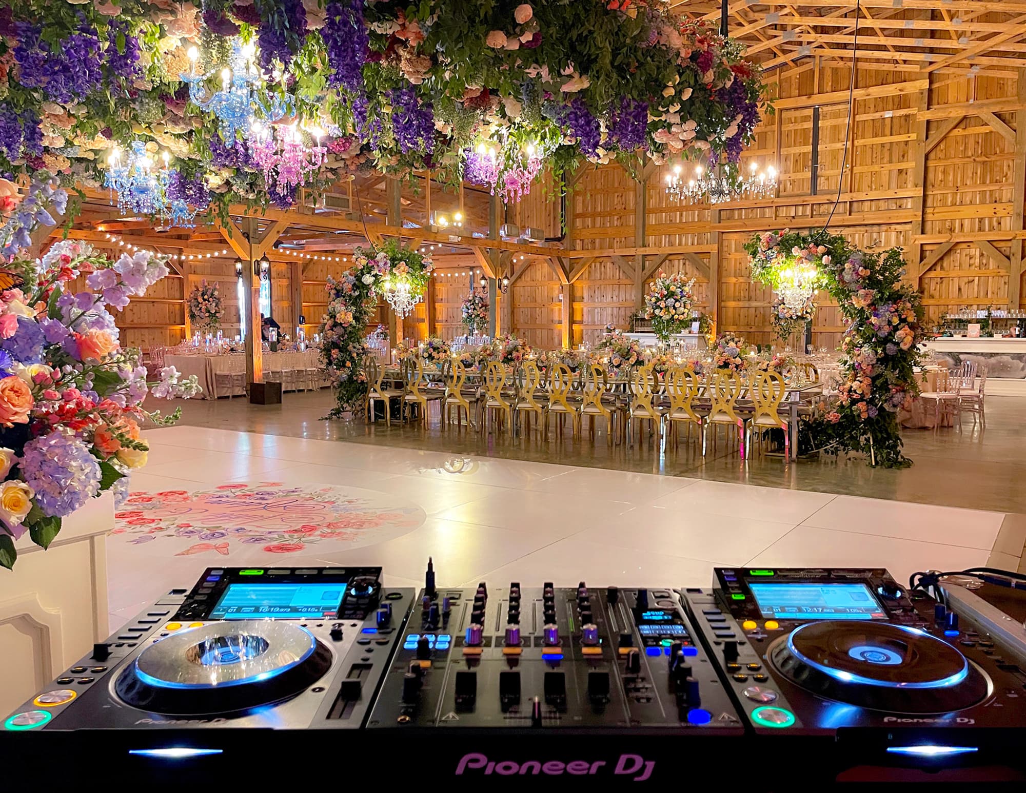 Golden Date DJ booth set up overlooking a floral wedding reception